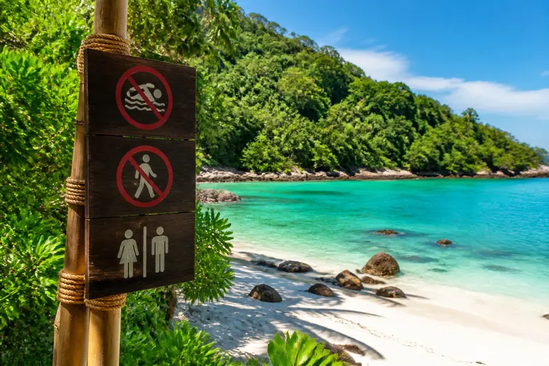 Ein Schild mit Verhaltensregeln für Besucher informiert über die Schutzzonen und Einschränkungen am Eingang der Maya Bay.