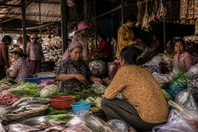 Ein geschäftiger Markt in Phnom Penh, wo einheimische Verkäufer Obst und Handwerk anbieten, inmitten des täglichen Lebens.