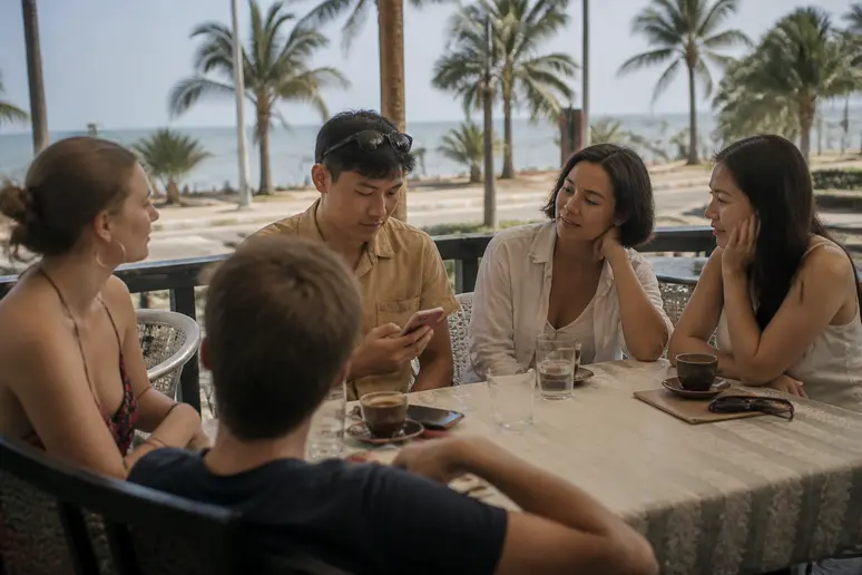 Touristen in Phuket entspannen sich in einem Café und passen sich an die neue Zeitzone an, während sie ihre Reisepläne prüfen.