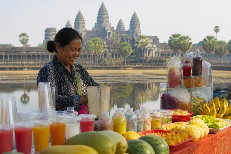 Straßenhändler verkauft Früchte in Siem Reap, angkor Tempelanlagen im Hintergrund.