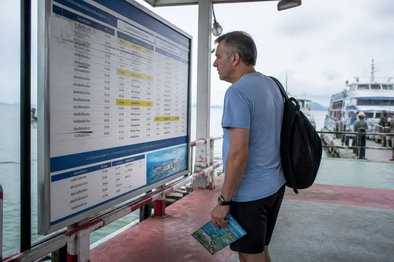 Deutscher Reisender prüft Fährzeiten für Bangkok nach Koh Samui, detaillierte Reiseplanung.