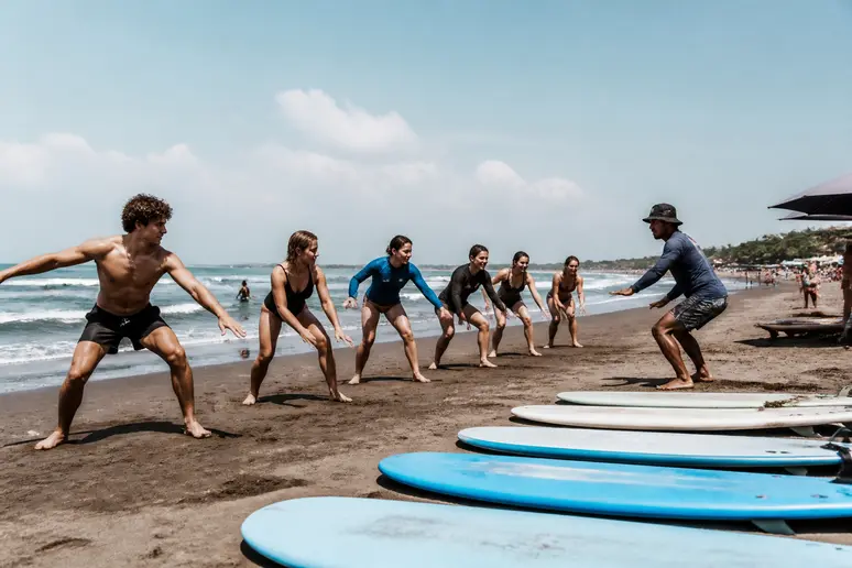Junge Leute lernen Surfen an den Stränden von canggu bali bei sonnigem Wetter.