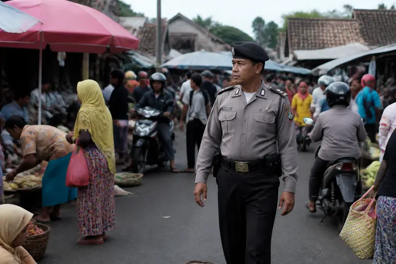 Indonesischer Polizist in Zivilkleidung achtet auf die Sicherheit, Einblicke in die indonesien karte.