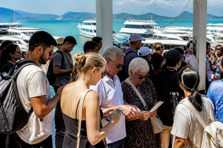 Reisende am Fährhafen von Phuket, planend ihre Anreise zur phi-phi-insel bei bestem Wetter.
