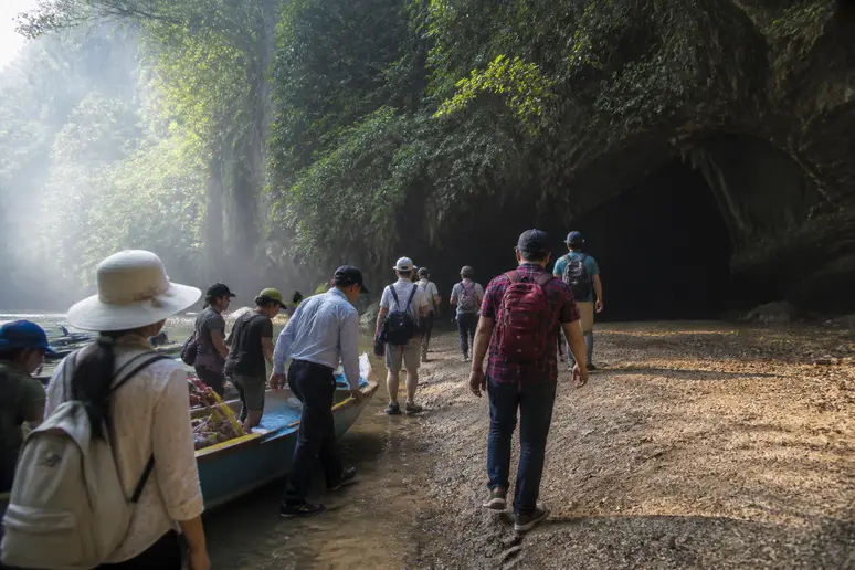 Touristen und Einheimische steigen in Phong Nha von einem Boot, um eine Höhle zu erkunden