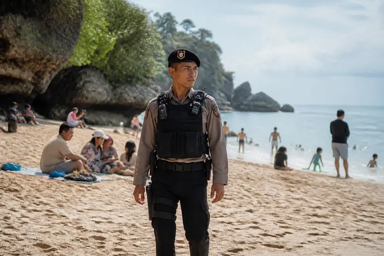 Polizist achtet auf Sicherheit am Strand von Uluwatu Bali, um Touristen zu schützen.