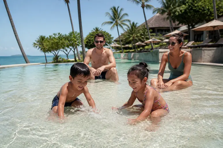 Familie im Pool eines familienfreundlichen koh samui island resort bei Sonnenschein