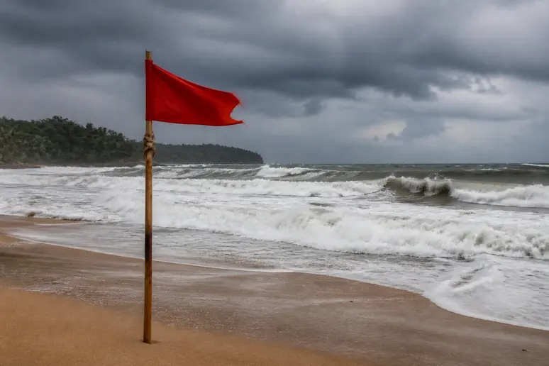 Rote Warnflagge am stürmischen Strand während vom Regenzeit Phuket Urlaub