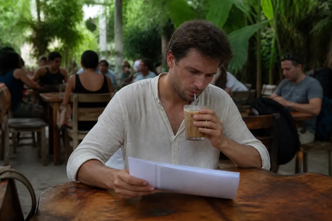 Reisender plant den Thailand-Urlaub im Café und liest airalo erfahrungen für die eSIM.