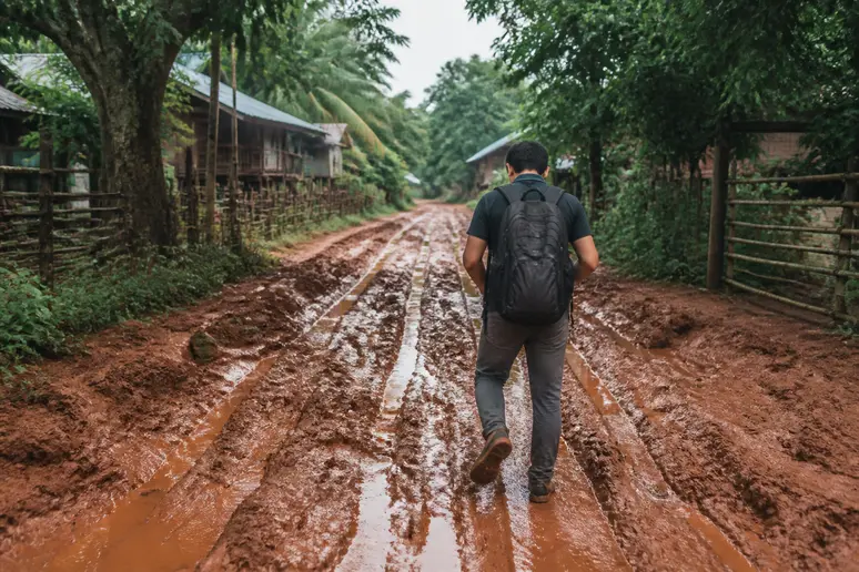Reisender auf einer schlammigen Straße während der Regenzeit in Kambodscha