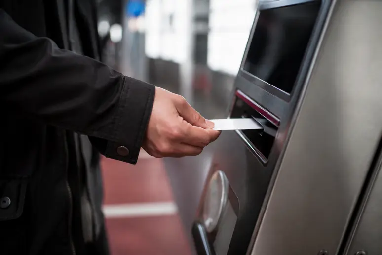 Fahrgast beim Lösen eines Fahrscheins am Ticketautomat der Station in Bangkok