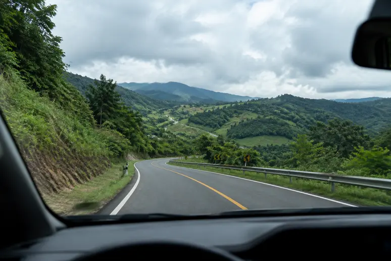 Fahrt auf einer kurvigen Straße durch die Hügellandschaft von Chiang Rai
