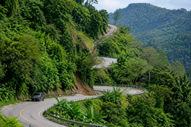 Gewundene Bergstraße führt durch den dichten Dschungel hinauf zum Doi Inthanon Nationalpark