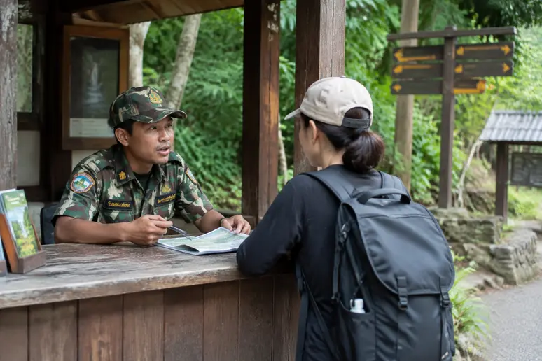 Parkranger am Kontrollpunkt für die Flaschenregelung am Erawan-Wasserfall