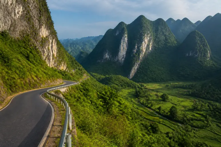 Gewundene Passstraße durch steile Kalksteinfelsen in der Bergregion von Ha Giang im Norden Vietnams