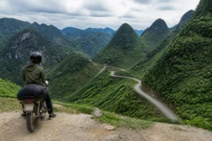 Ein Reisender auf einem Motorrad bewundert die bergige Landschaft beim ha giang loop