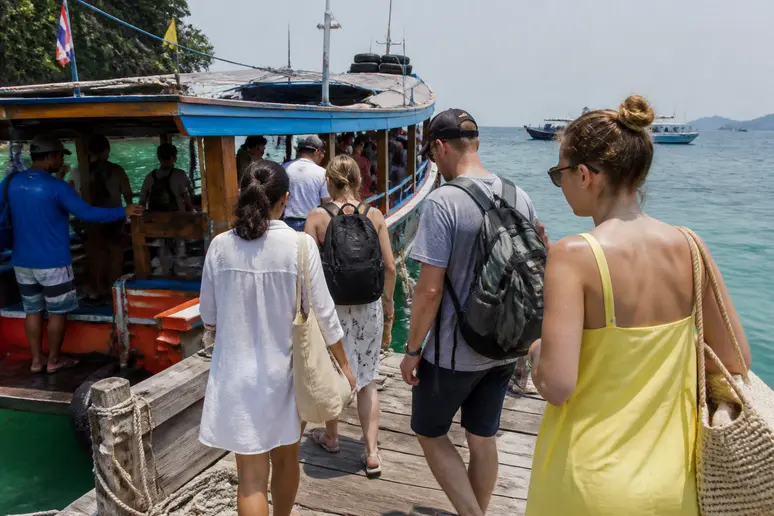 Reisende beim Bootstransfer am Pier für die Anreise zum C&N Kho Khao Beach Resort