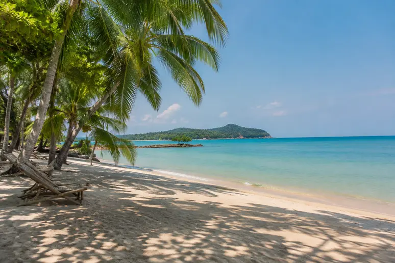 Ruhiger tropischer Strand auf Koh Lanta mit Palmen und klarem Wasser