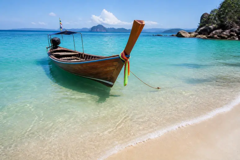 Ruhiges blaues Meer und traditionelle Boote während der optimalen Reisezeit in der Trockenperiode