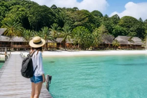 Reisende auf dem hölzernen Steg von koh rong samloem mit Blick auf den Strand