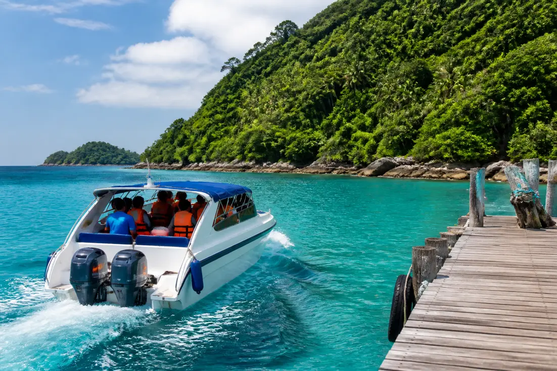 Ein Speedboot fährt vom Steg ab zum Koh Tarutao Nationalpark in Thailand.