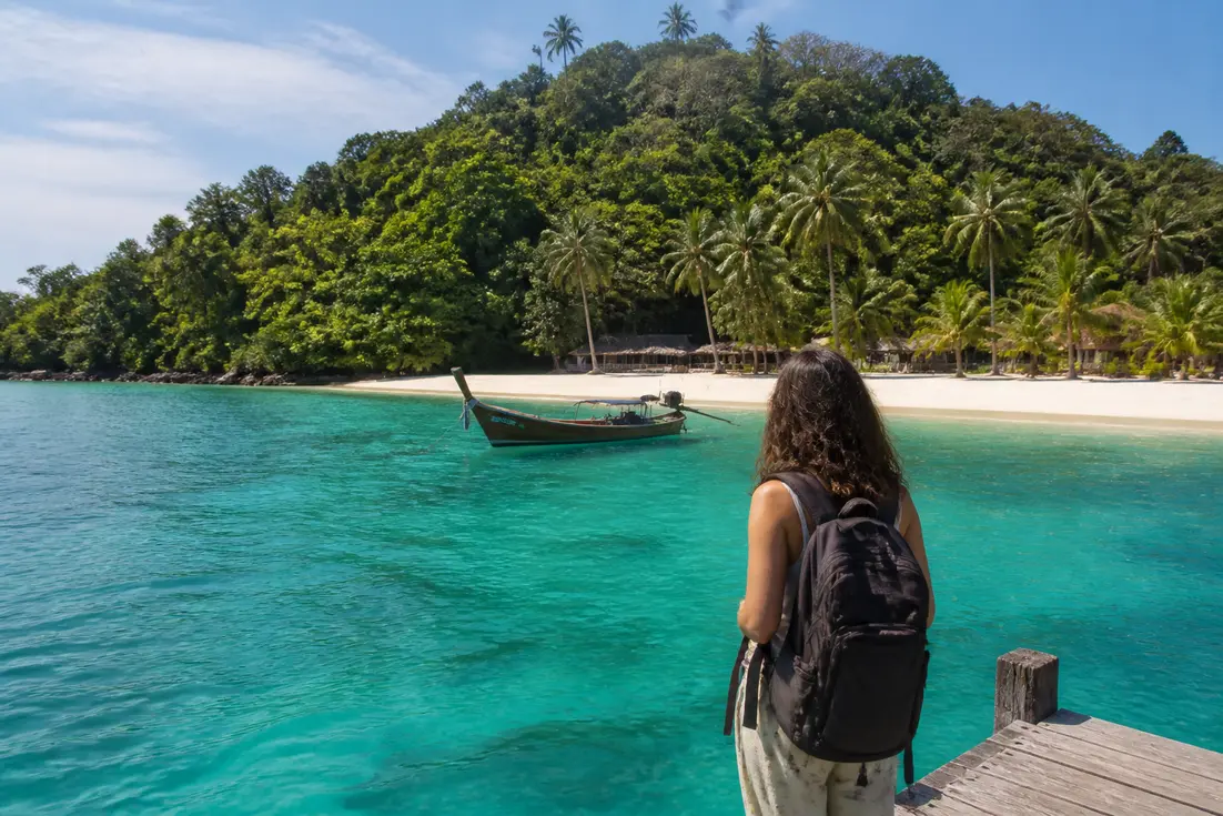 Entspannter Reisender auf einem Holzsteg während einem Koh Wai Inselhopping Ostthailand im kristallklaren Meer.