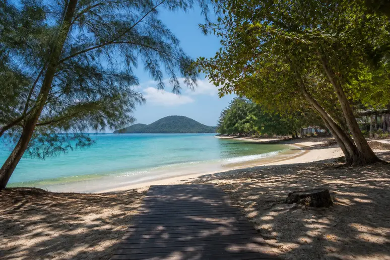 Entspannter Sandstrand mit schattenspendenden Bäumen und ruhiger Atmosphäre an der Relax Bay auf Koh Lanta
