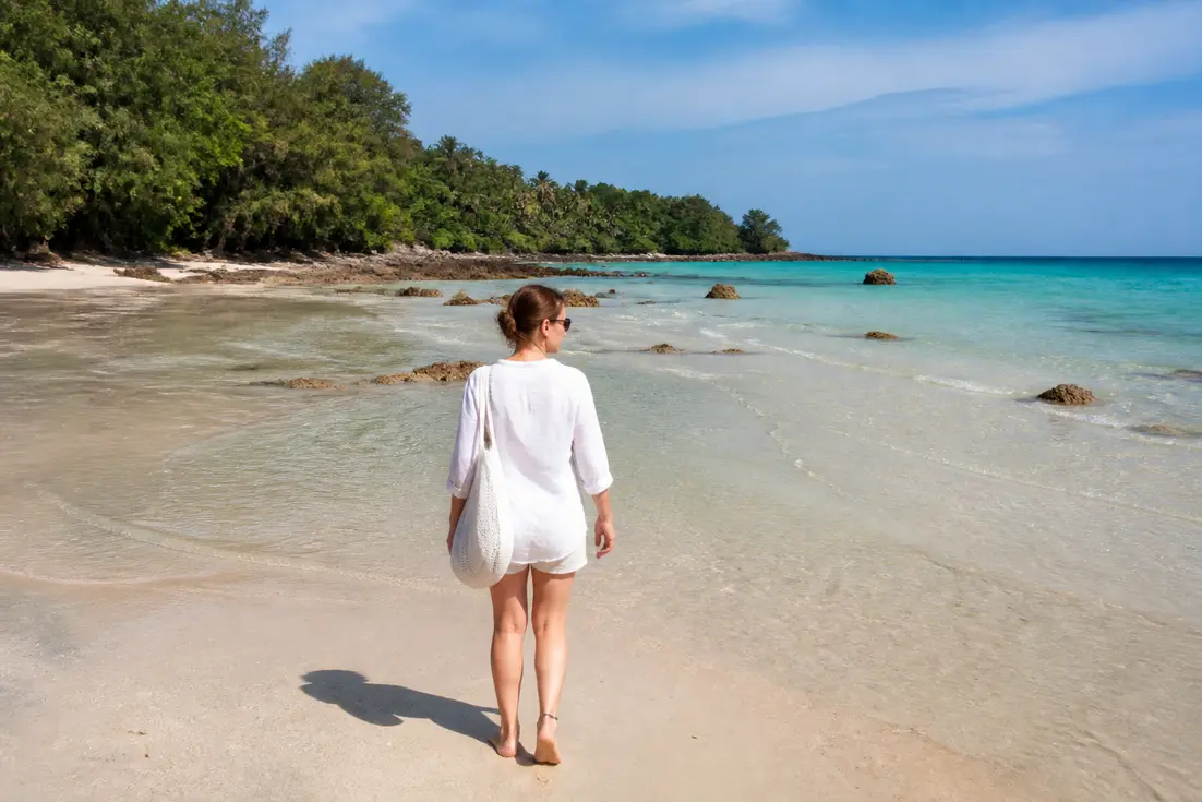 Malerischer Strand an der Relax Bay Koh Lanta mit flachem Wasser bei Ebbe und tropischen Bäumen.