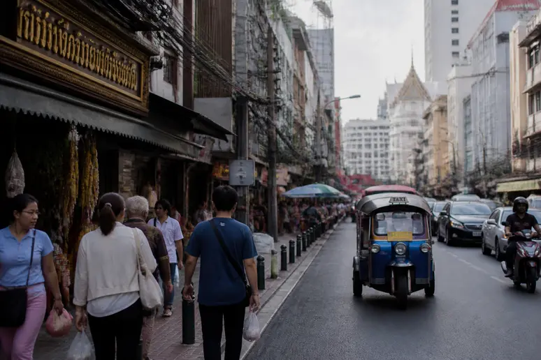 Straßenszene in Bangkok mit thailändischen Schildern und internationaler Atmosphäre
