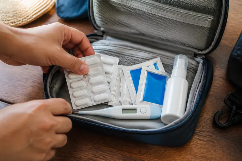 Kompakte Thailand Reiseapotheke mit Paracetamol, Elektrolyten und Mückenschutz auf einem Tisch
