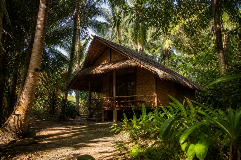 Einfache Bambusbungalows im Schatten von Palmen auf der ruhigen Insel Koh Chang Ranong