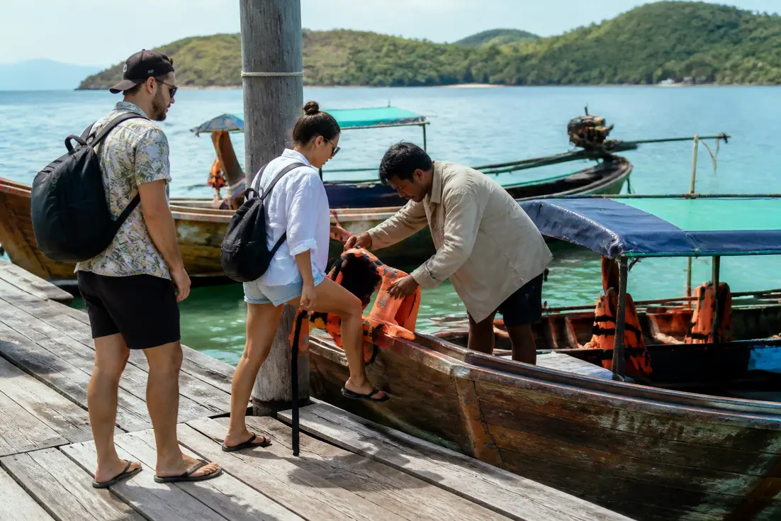 Touristen bereiten sich am Steg auf eine Bootsfahrt vor in diesem Koh Muk Reiseführer