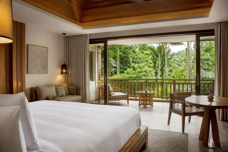 Modernes Zimmer mit Balkon und Blick in die tropische Gartenanlage des Resorts