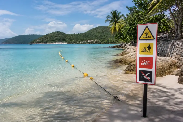 Gelbe Bojen markieren ein Schutznetz im klaren Wasser an einem Strand auf Koh Phangan