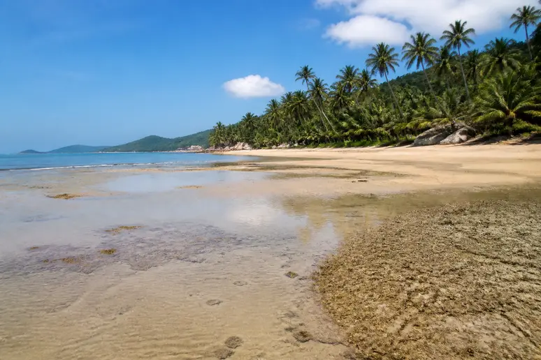 Flaches Wasser und freiliegende Sandbank an einem tropischen Strand zur Ebbezeit auf Koh Phangan