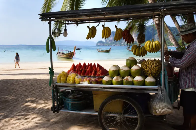 Mobiles Verkaufsfahrzeug mit frischem Obst am sonnigen Strand von Surin
