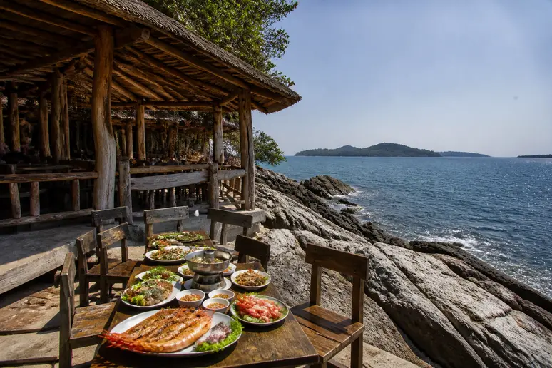 Traditionelles Restaurant auf Felsen mit Blick auf das Meer in Thailand