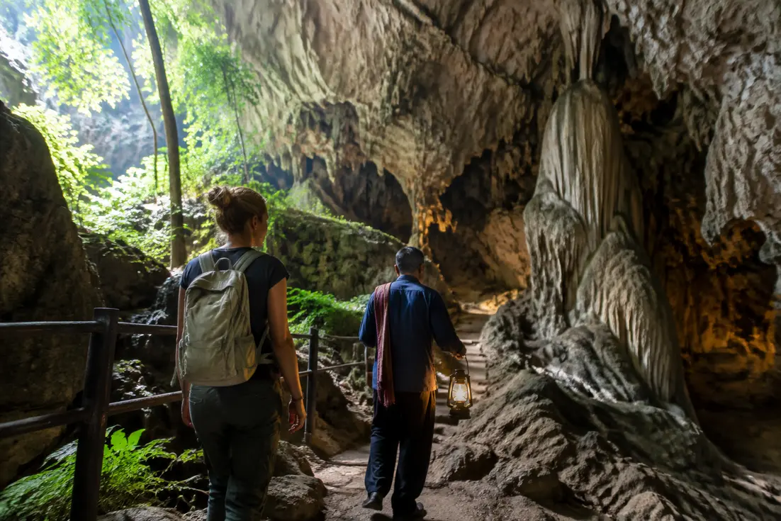 Besucher erkunden den Höhleneingang bei thailand chiang dao im Tageslicht