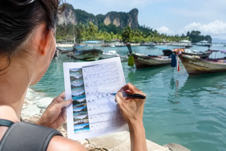 Reisender streicht ungeeignete Termine im thailändischen Reiseplan vor einer Bootstour durch
