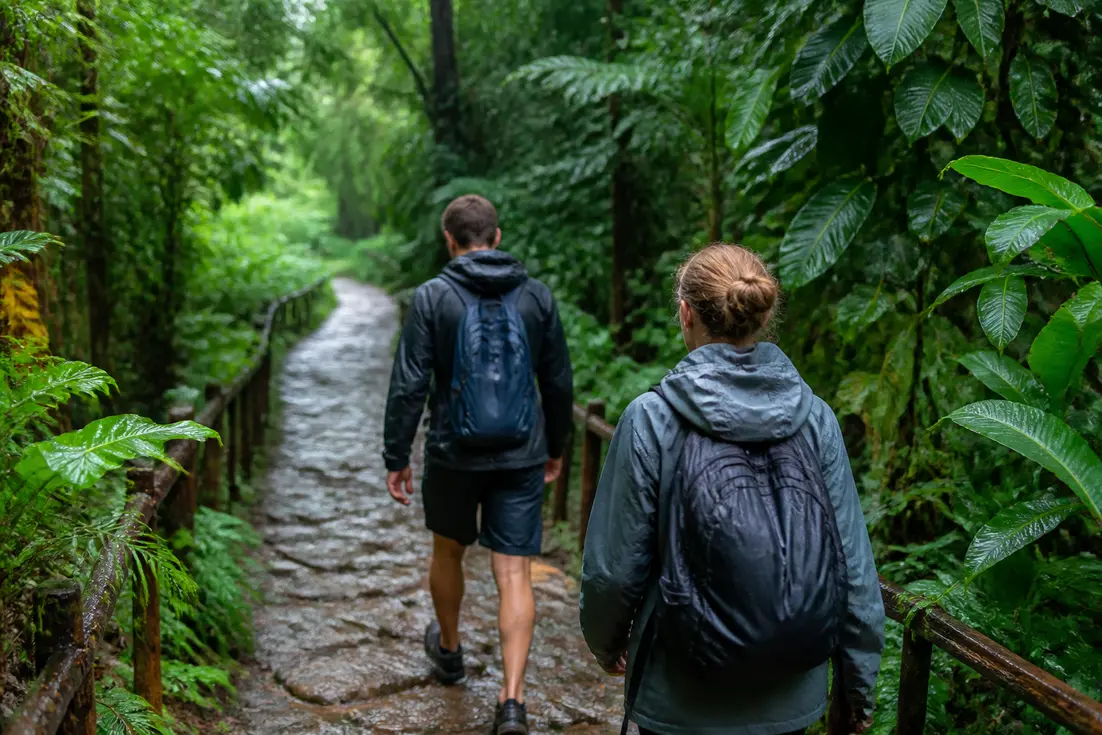 Wanderer mit Regenjacken auf einem nassen Pfad in Thailand im November